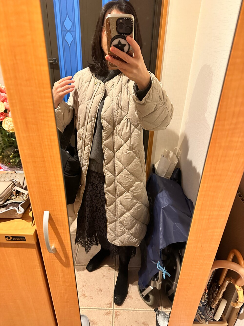 グレー系のニット/セーター、ベージュ系のダウンジャケット/コート、ブラック系のシューズを着用したレディースの冬コーディネートの3枚目の写真