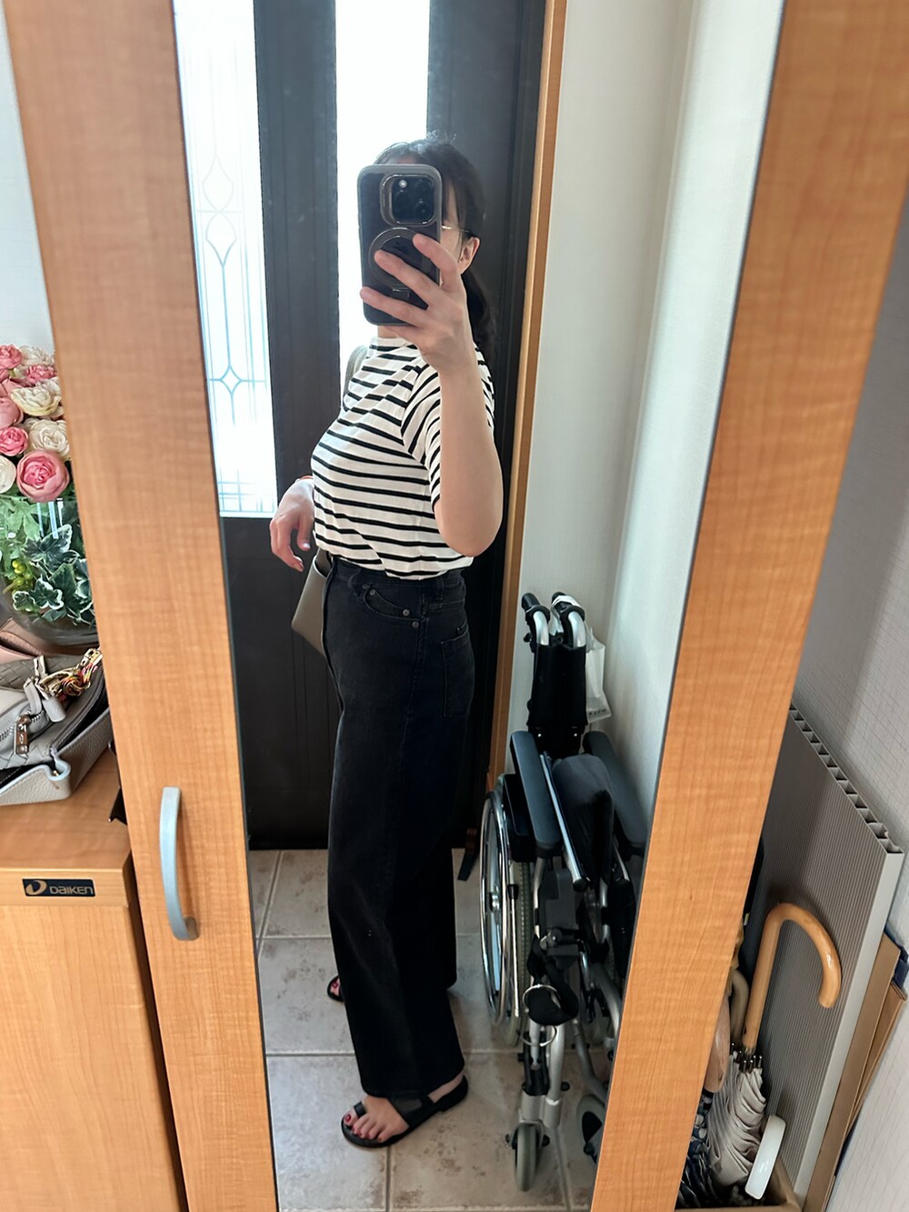 ブラック系のTシャツ/カットソー、ブラック系のデニムパンツ、ブラック系のサンダルを着用したレディースの夏コーディネートの2枚目の写真