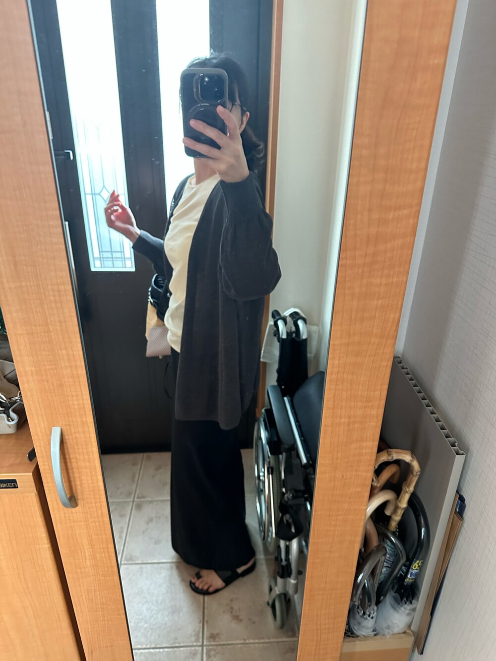 ホワイト系のキャミソール、グレー系のカーディガン/ボレロ、ベージュ系のTシャツ/カットソーを着用したレディースの春コーディネートの2枚目の写真