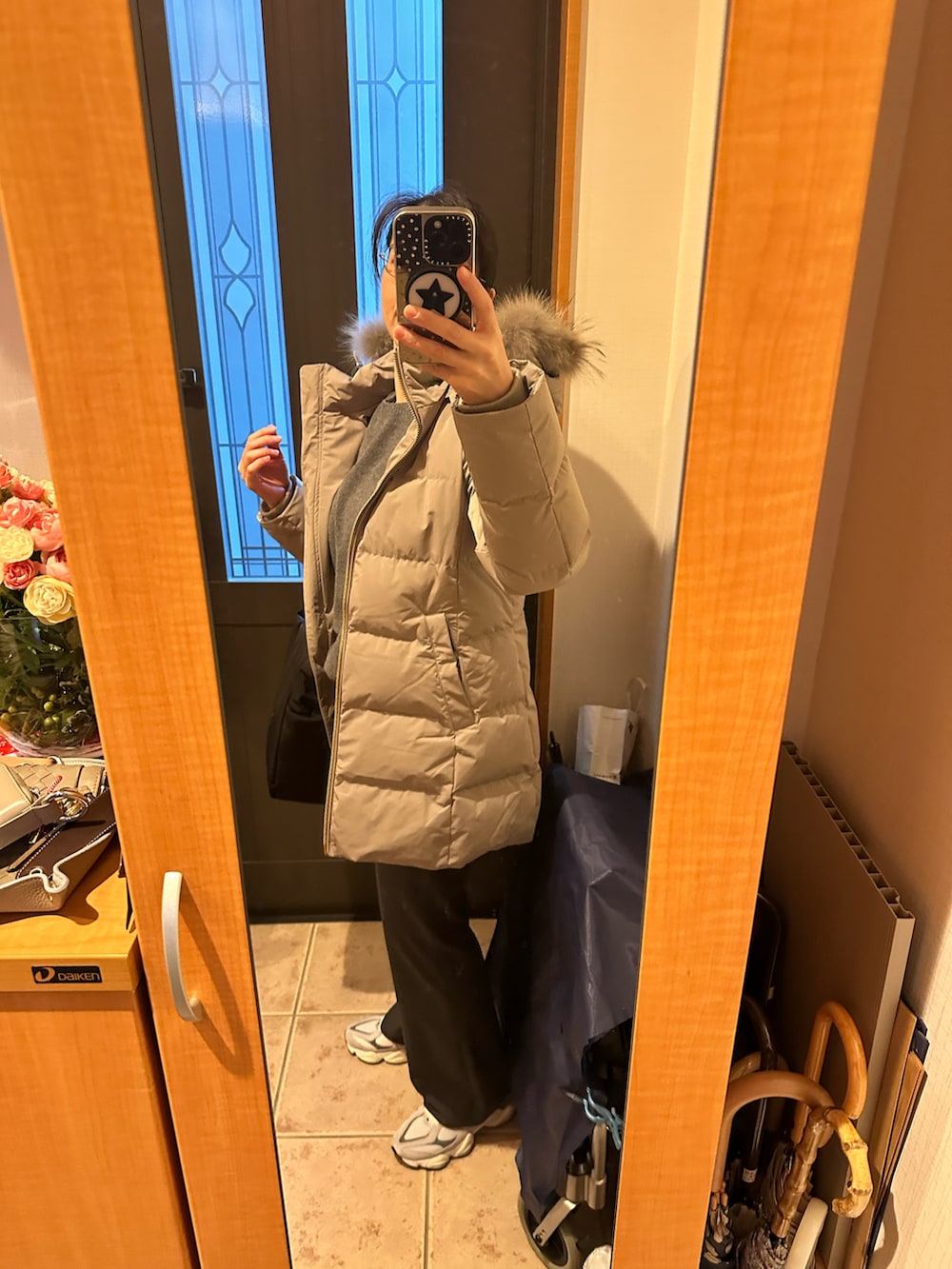 グレー系のニット/セーター、ブラック系のトートバッグ、グレー系のスラックスを着用したレディースの冬コーディネートの4枚目の写真