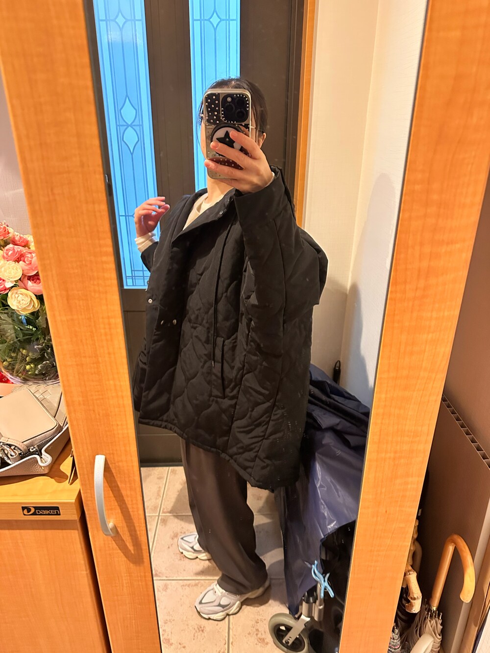 ベージュ系のニット/セーター、ホワイト系のTシャツ/カットソー、ブラック系のトートバッグを着用したレディースの冬コーディネートの4枚目の写真