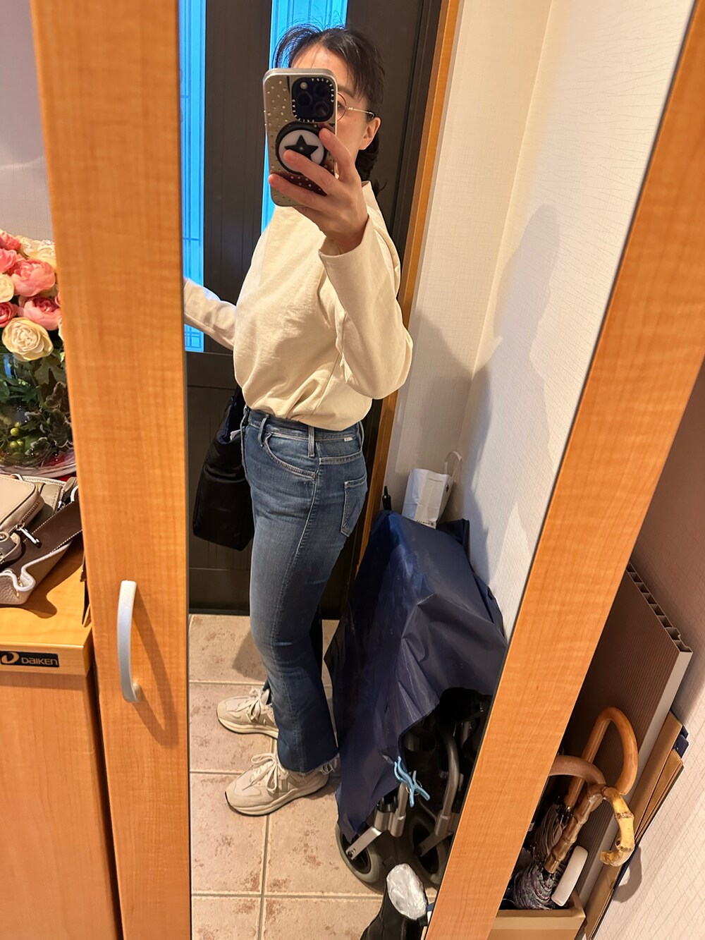 ホワイト系のTシャツ/カットソー、ブルー系のデニムパンツ、グレー系のスニーカーを着用したレディースの冬コーディネートの2枚目の写真