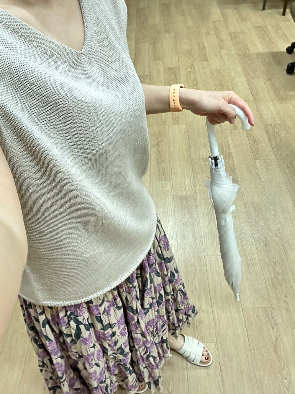 ベージュ系のニット/セーター、ベージュ系のスカート、ホワイト系のサンダルを着用したレディースの夏コーディネートの3枚目の写真