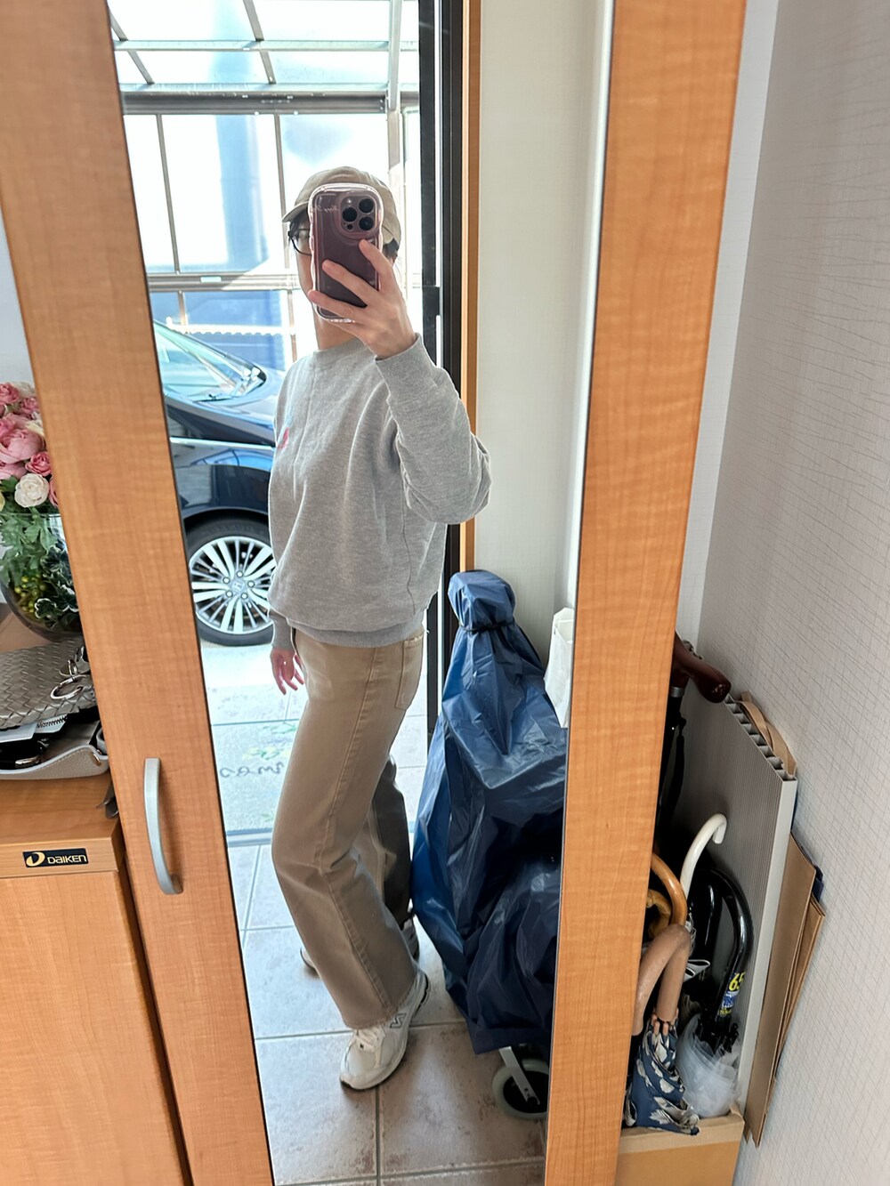 ベージュ系のデニムパンツ、ホワイト系のスニーカー、ベージュ系のキャップを着用したレディースの冬コーディネートの2枚目の写真