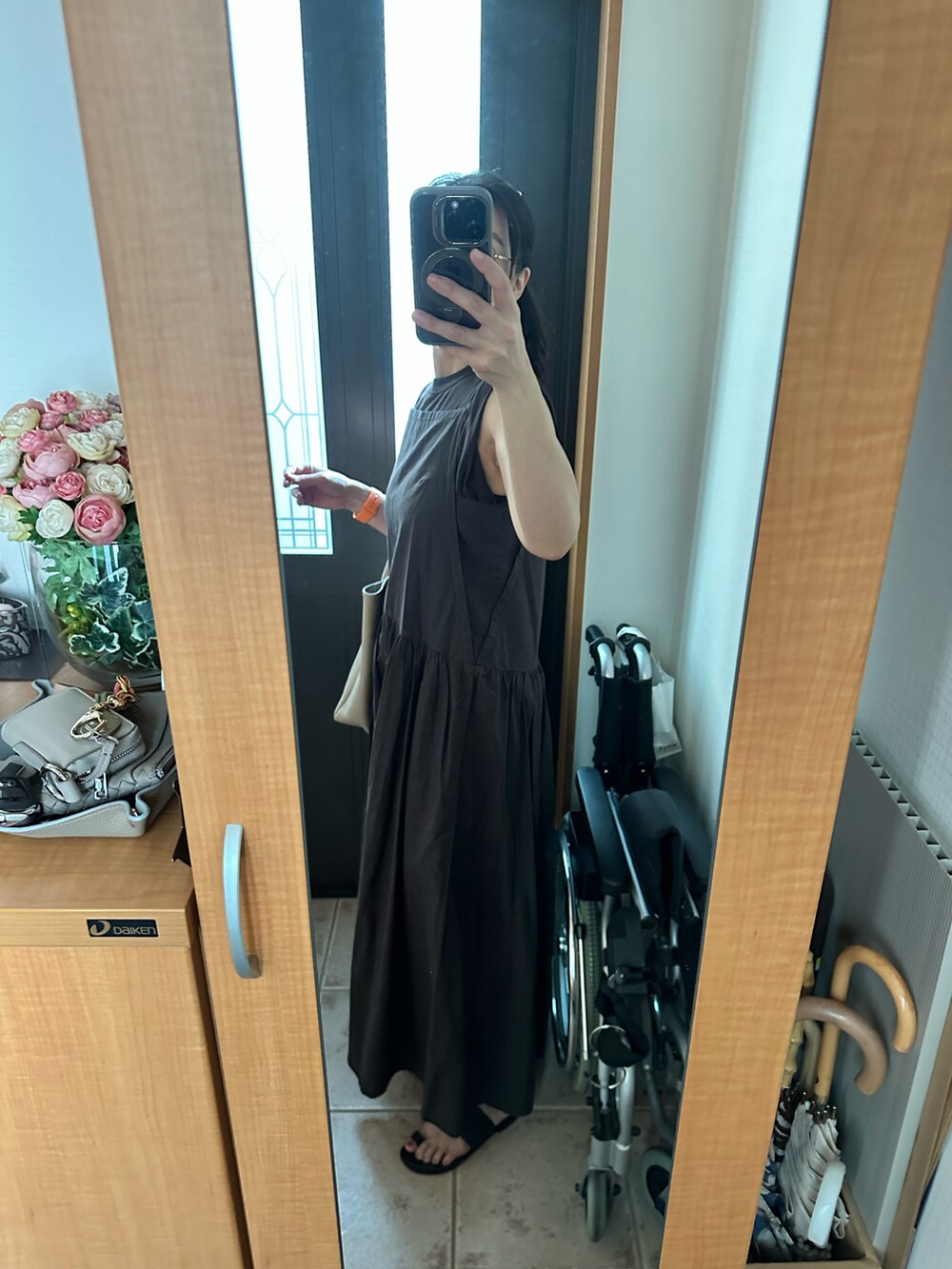 ベージュ系のトートバッグ、グレー系のワンピース、ブラウン系のタンクトップを着用したレディースの夏コーディネートの2枚目の写真