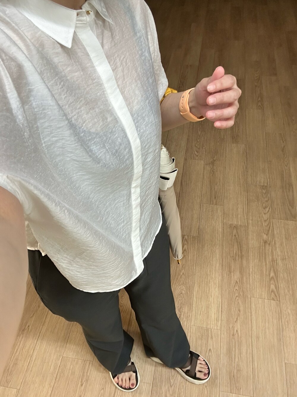 ホワイト系のシャツ/ブラウス、グレー系のスラックス、ブラウン系のサンダルを着用したレディースの夏コーディネートの3枚目の写真