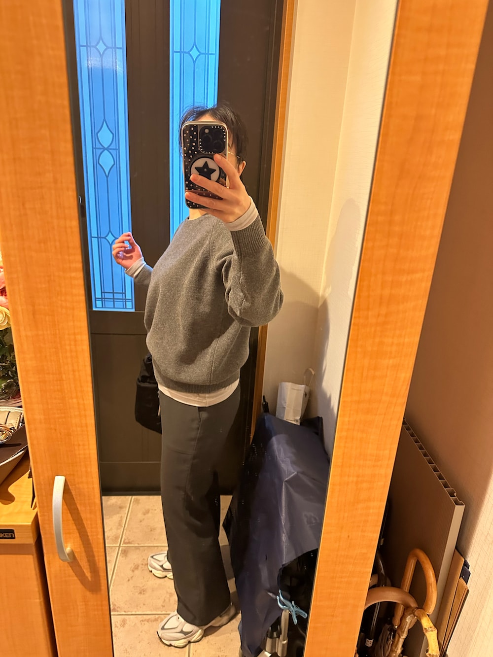 グレー系のニット/セーター、ブラック系のトートバッグ、グレー系のスラックスを着用したレディースの冬コーディネートの2枚目の写真