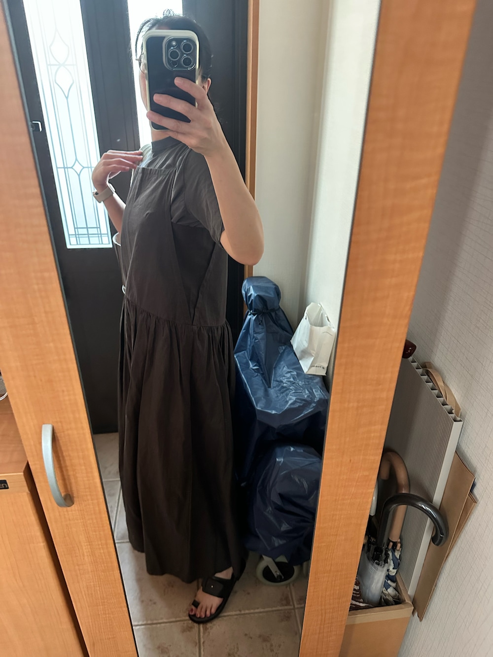 グレー系のワンピース、ブラック系のサンダル、グレー系のTシャツ/カットソーを着用したレディースの夏コーディネートの2枚目の写真