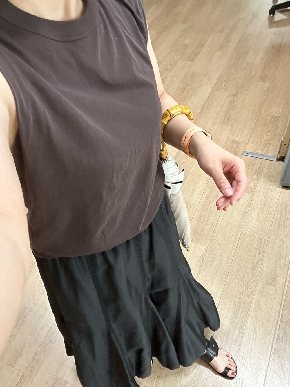 ブラウン系のタンクトップ、ブラック系のスカート、ブラック系のサンダルを着用したレディースの夏コーディネートの3枚目の写真