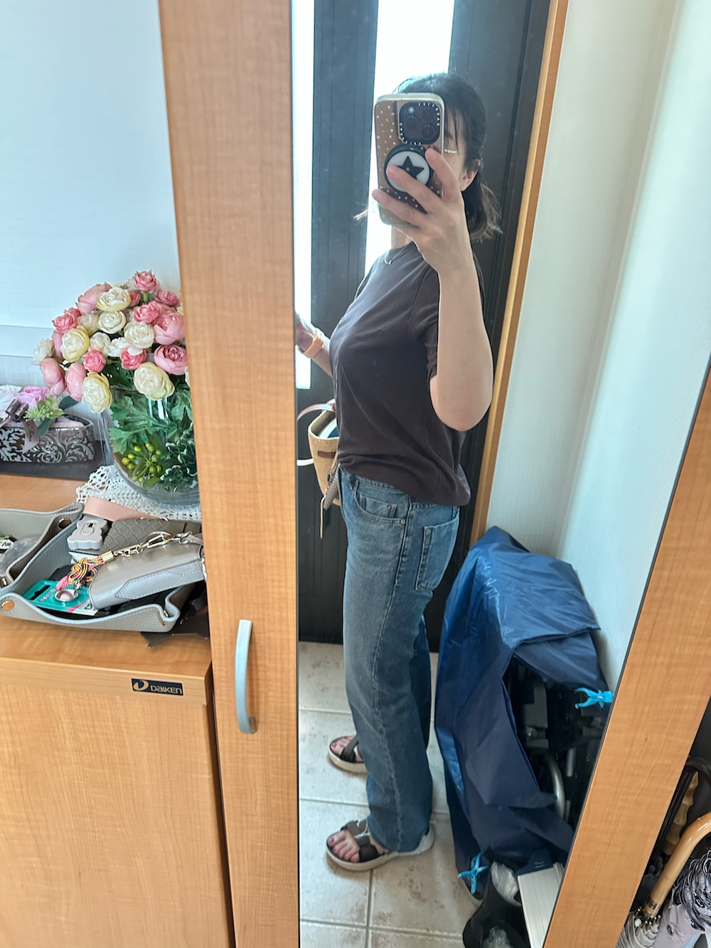 ブラウン系のTシャツ/カットソー、ブルー系のデニムパンツ、ブラウン系のサンダルを着用したレディースの夏コーディネートの2枚目の写真