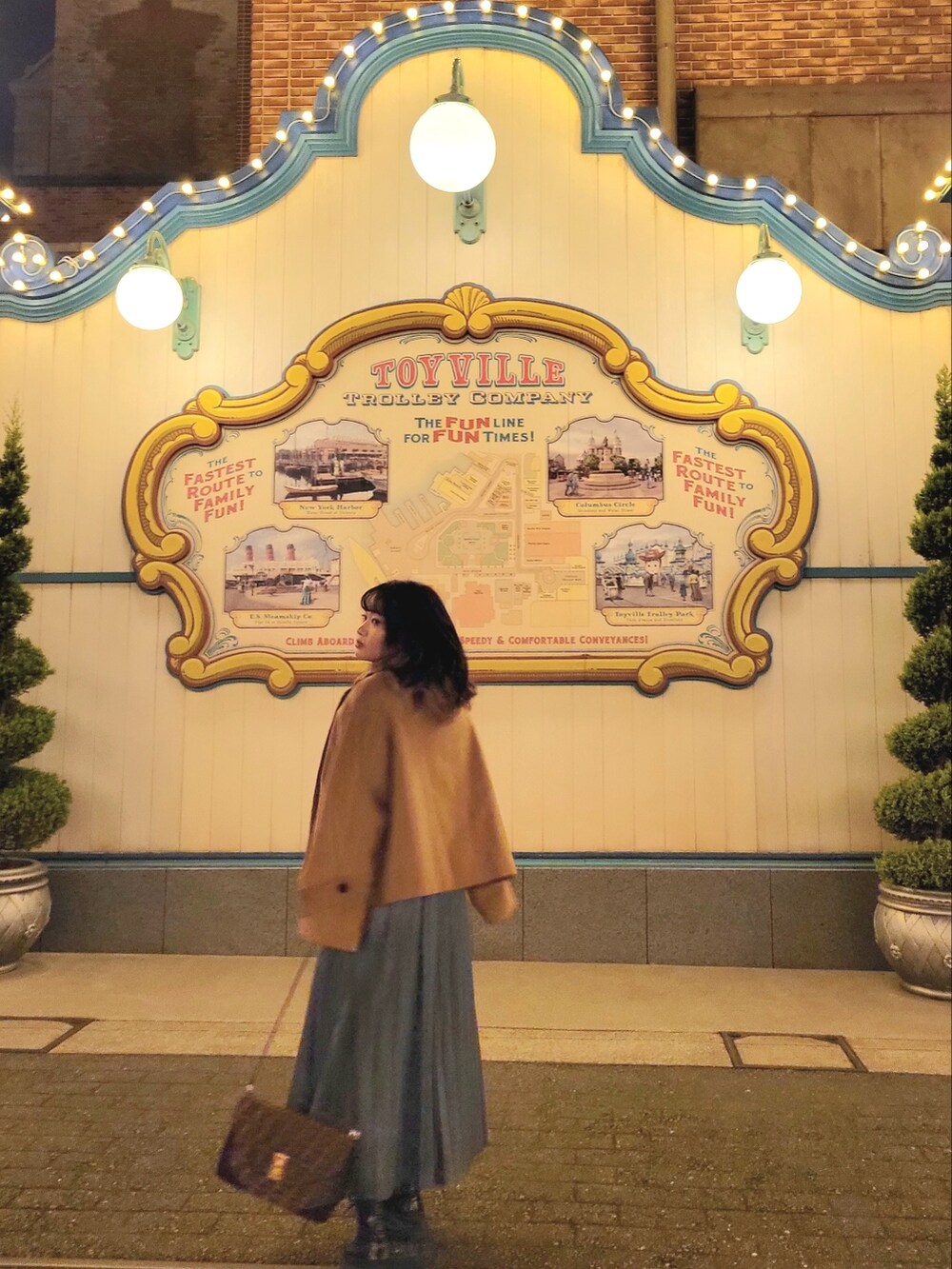 ブラウン系のハンドバッグ、ブラウン系のジャケット/アウター、ブルー系のスカートを着用したレディースの秋コーディネートの2枚目の写真