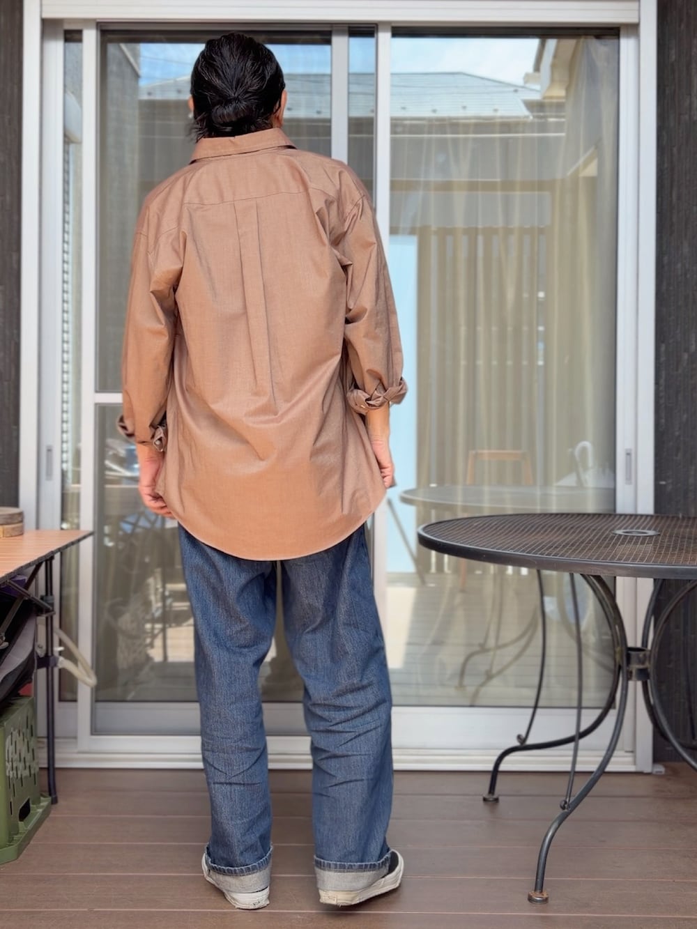 ブルー系のデニムパンツ、ブラック系のスニーカー、ブラック系のTシャツ/カットソーを着用したメンズの春コーディネートの3枚目の写真