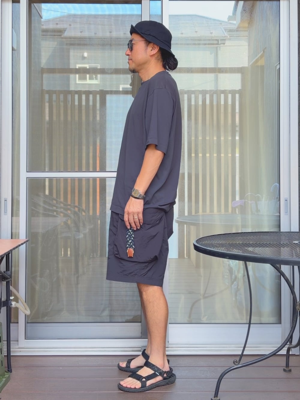 グレー系のTシャツ/カットソー、ブラック系のその他パンツ、ブラック系のサンダルを着用したメンズの夏コーディネートの2枚目の写真