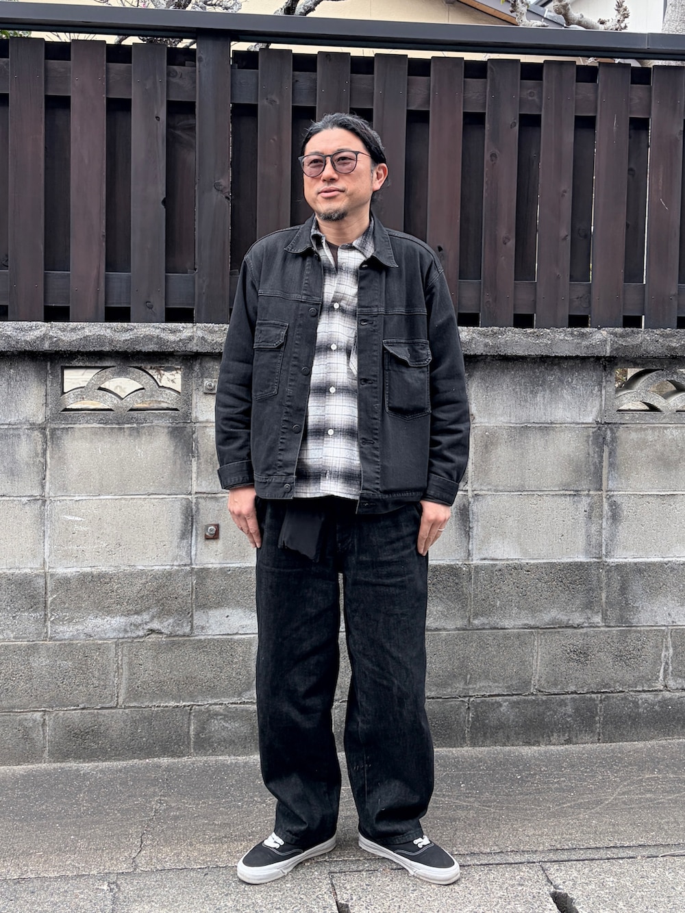 ブラック系のスニーカー、ブラック系のデニムジャケット、ブラック系のデニムパンツを着用したメンズの冬コーディネートの2枚目の写真