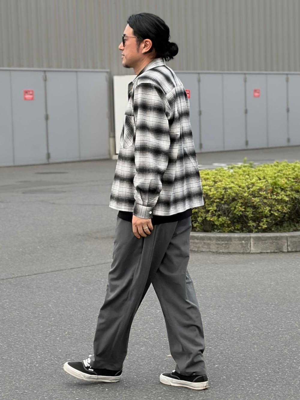 グレー系のスラックス、ブラック系のシャツ/ブラウス、ブラック系のスニーカーを着用したメンズの春コーディネートの2枚目の写真