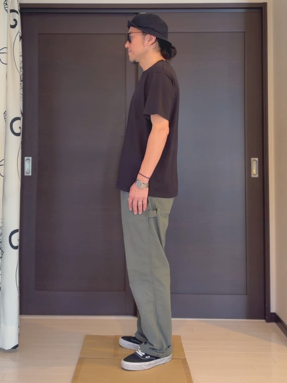 ブラック系のTシャツ/カットソー、グリーン系のその他パンツ、ブラック系のスニーカーを着用したメンズの夏コーディネートの2枚目の写真