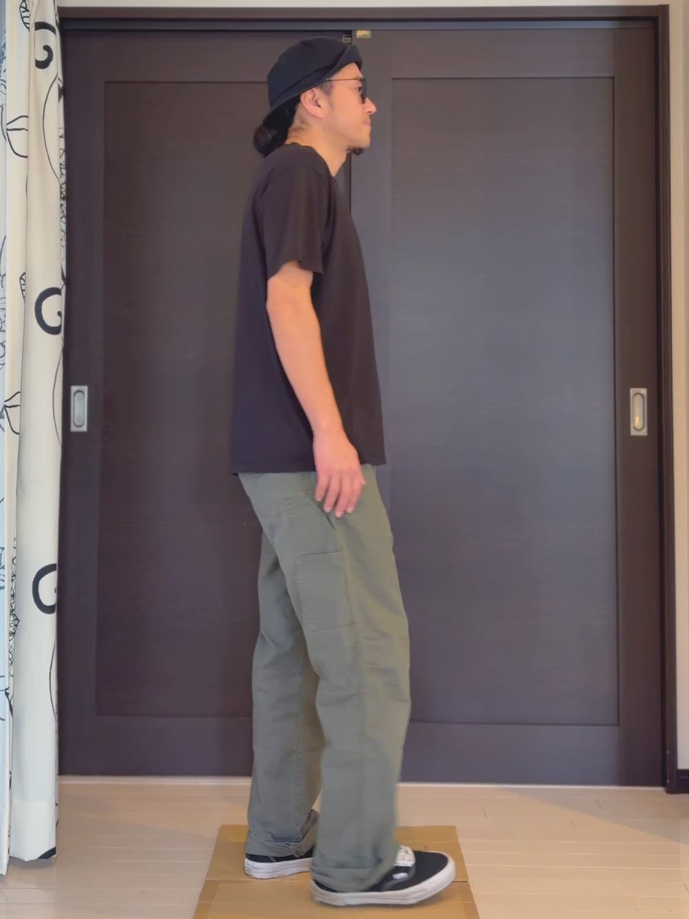 ブラック系のTシャツ/カットソー、グリーン系のその他パンツ、ブラック系のスニーカーを着用したメンズの夏コーディネートの3枚目の写真