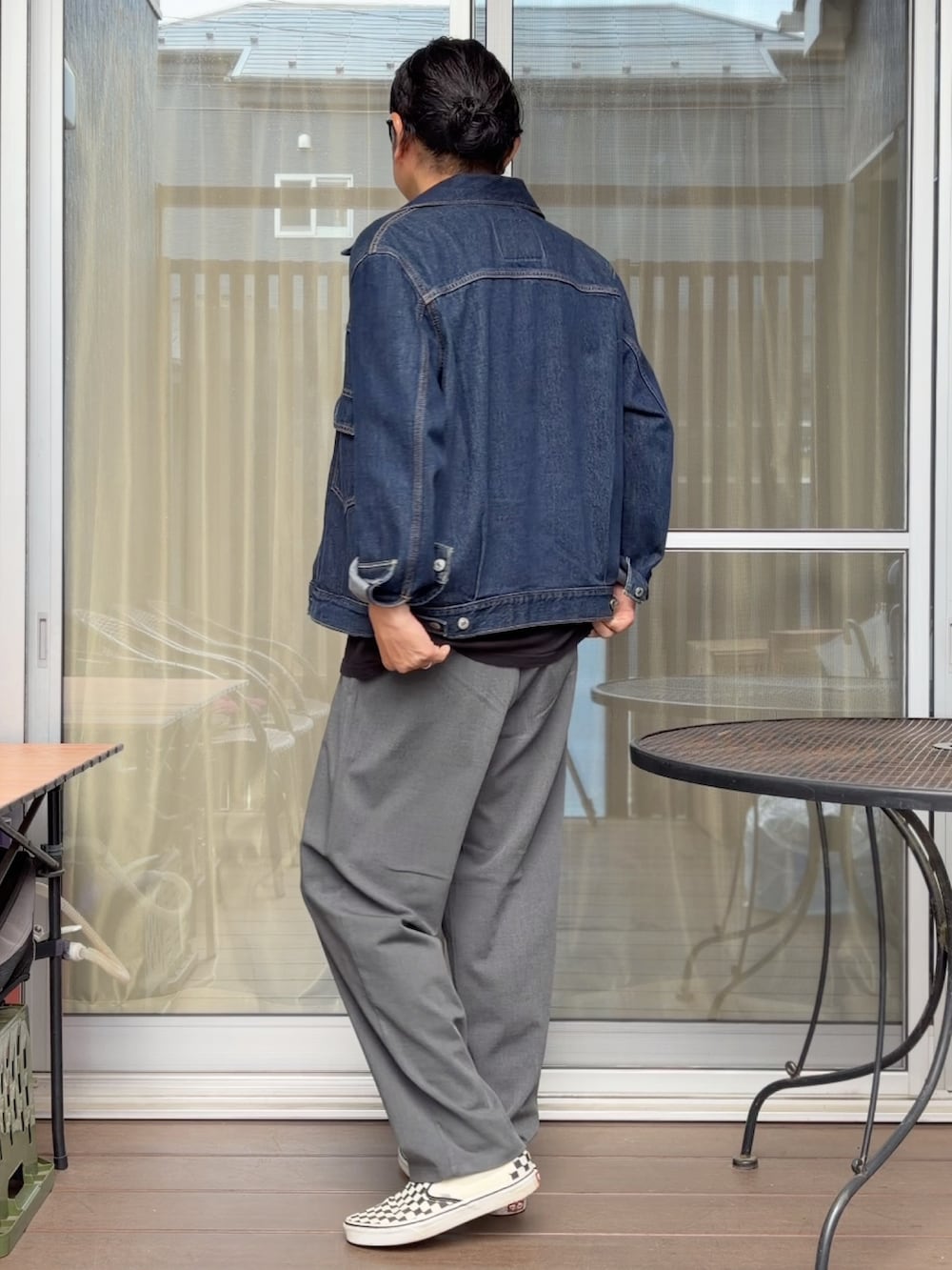 グレー系のスラックス、その他のスニーカー、ブルー系のデニムジャケットを着用したメンズの夏コーディネートの2枚目の写真