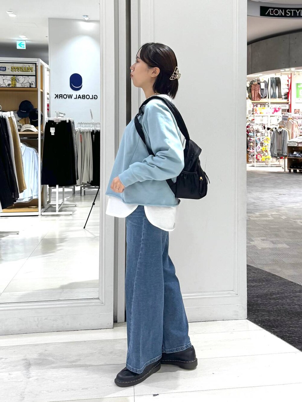 ブラック系のバックパック/リュック、ホワイト系のTシャツ/カットソー、ブルー系のデニムパンツを着用したレディースの秋コーディネートの4枚目の写真