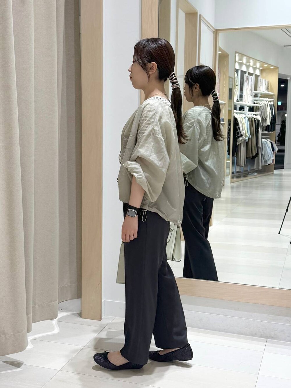 ブラック系のバレエシューズ、ホワイト系のショルダーバッグ、グリーン系のブルゾンを着用したレディースの春コーディネートの5枚目の写真