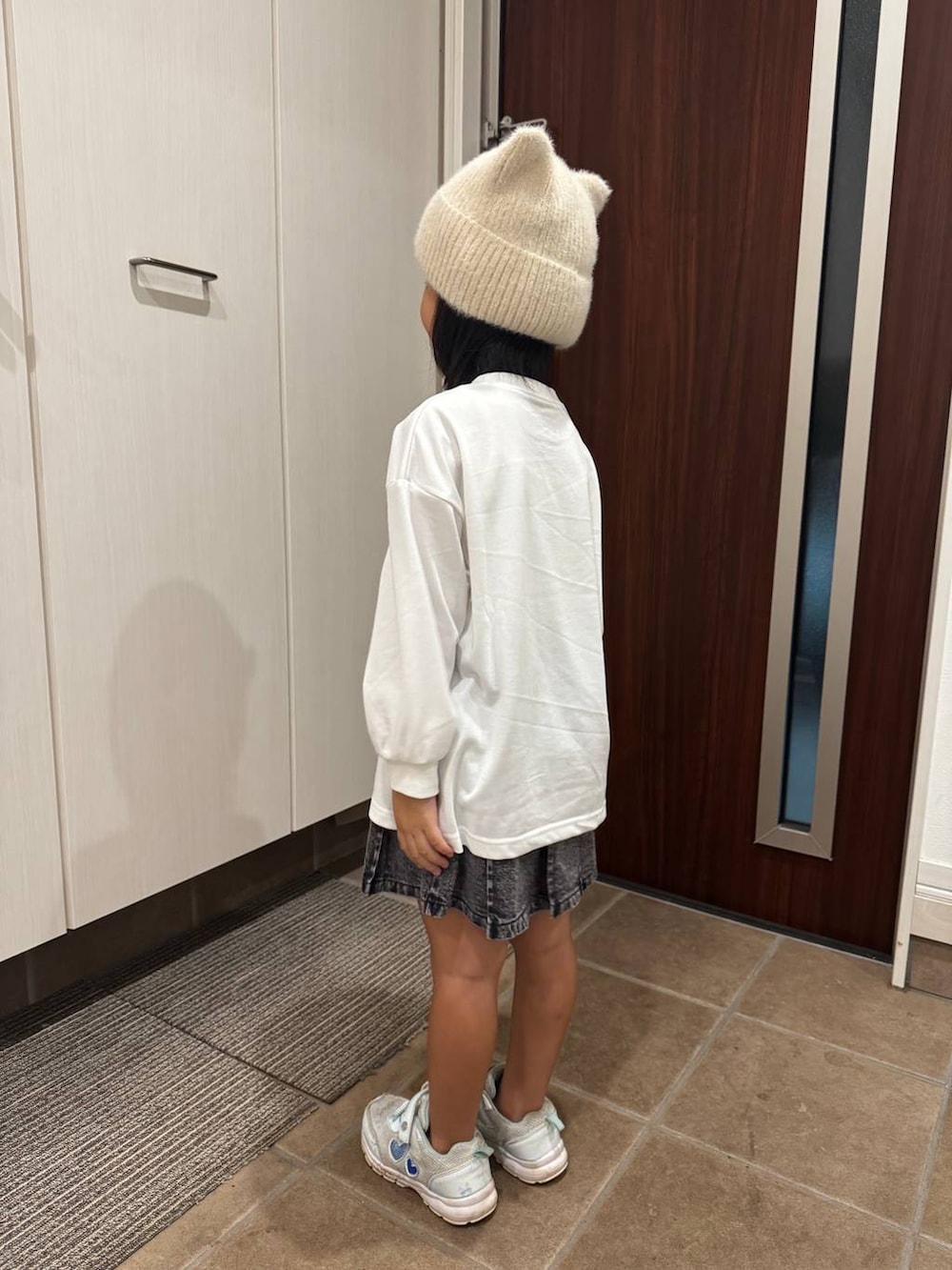 ブラック系のデニムスカート、ホワイト系のTシャツ/カットソーを着用したキッズの秋コーディネートの4枚目の写真