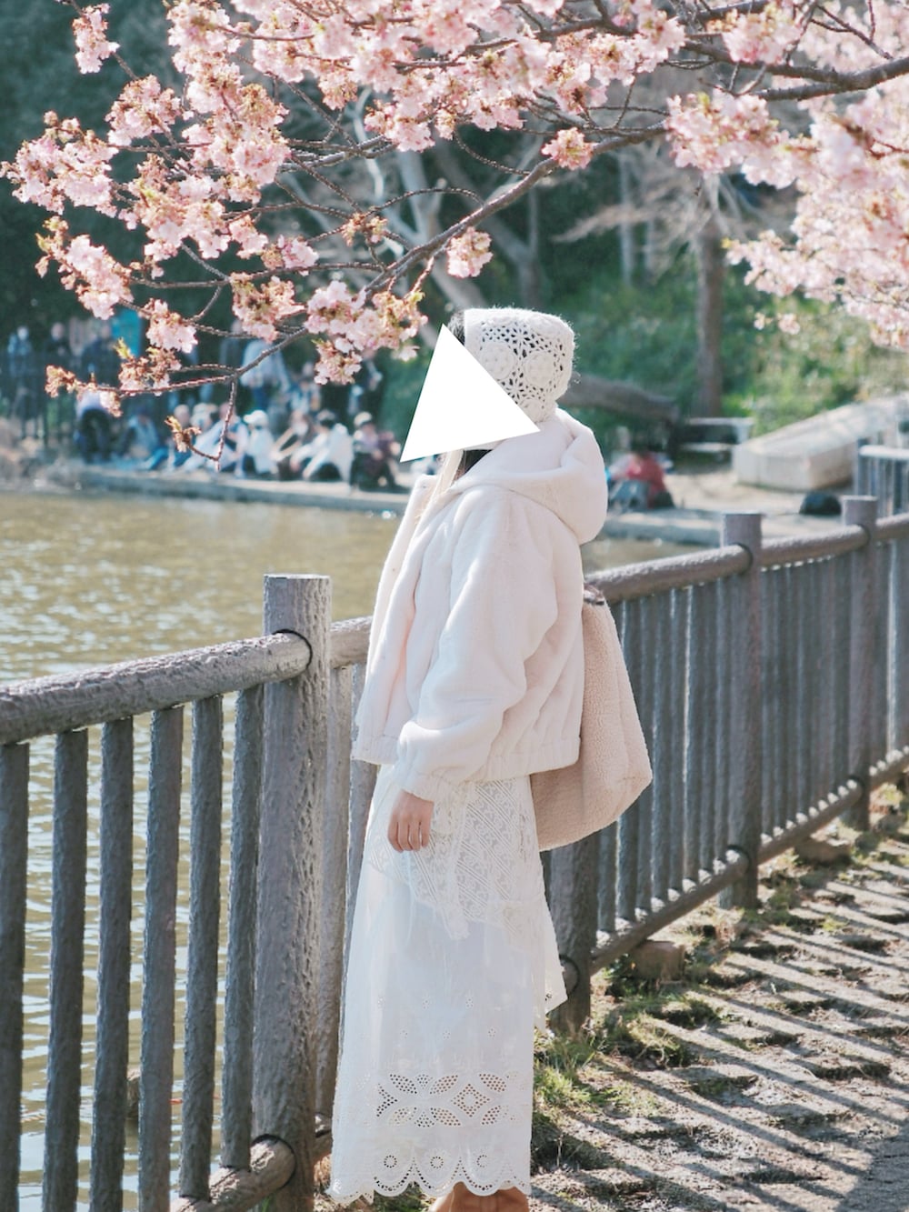 ホワイト系のブルゾン、ホワイト系のジャンパースカート、ホワイト系のTシャツ/カットソーを着用したレディースの冬コーディネートの2枚目の写真