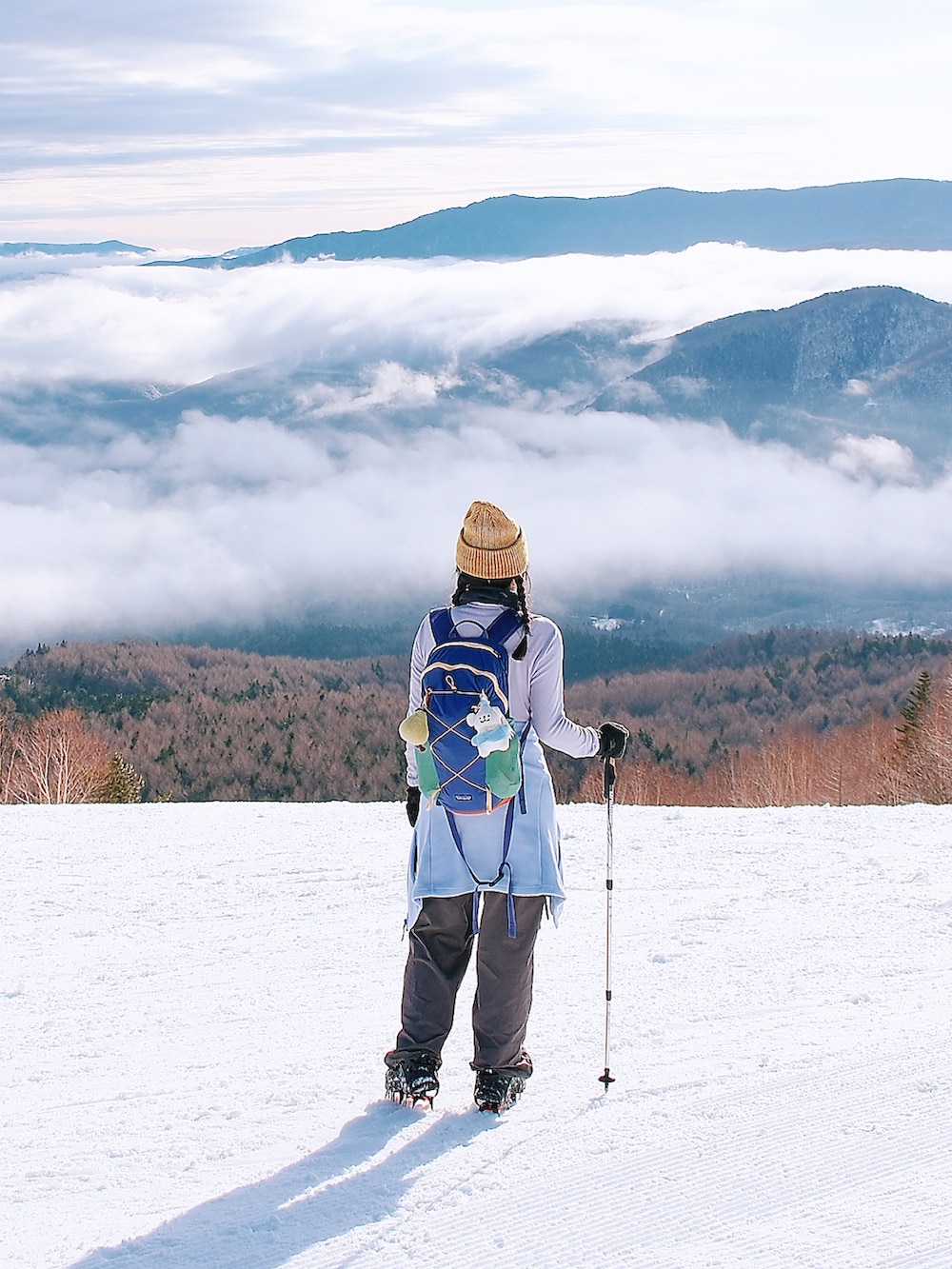 パープル系のTシャツ/カットソー、グレー系のチノパンツ、パープル系のバックパック/リュックを着用したレディースの春コーディネートの4枚目の写真
