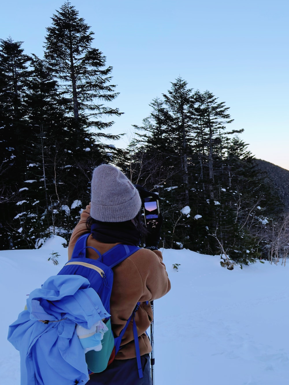 パープル系のマウンテンパーカー、グリーン系のその他シューズ、グレー系のチノパンツを着用したレディースの冬コーディネートの4枚目の写真