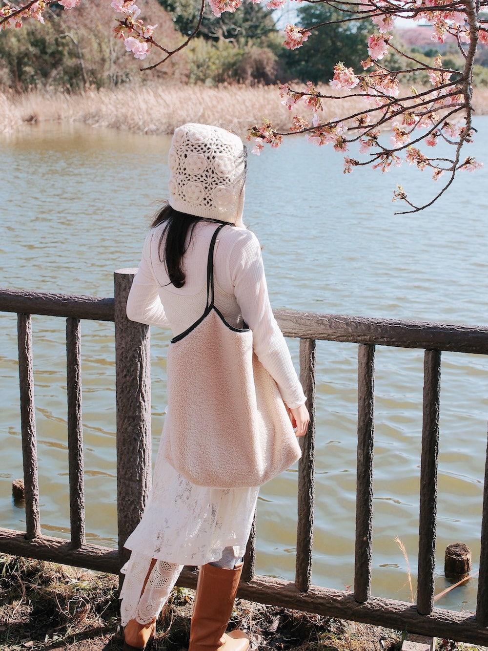 ホワイト系のブルゾン、ホワイト系のジャンパースカート、ホワイト系のTシャツ/カットソーを着用したレディースの冬コーディネートの4枚目の写真