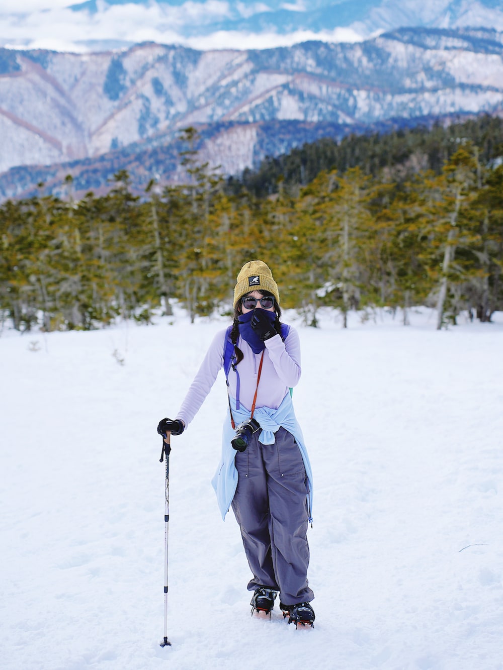 パープル系のTシャツ/カットソー、グレー系のチノパンツ、パープル系のバックパック/リュックを着用したレディースの春コーディネートの2枚目の写真