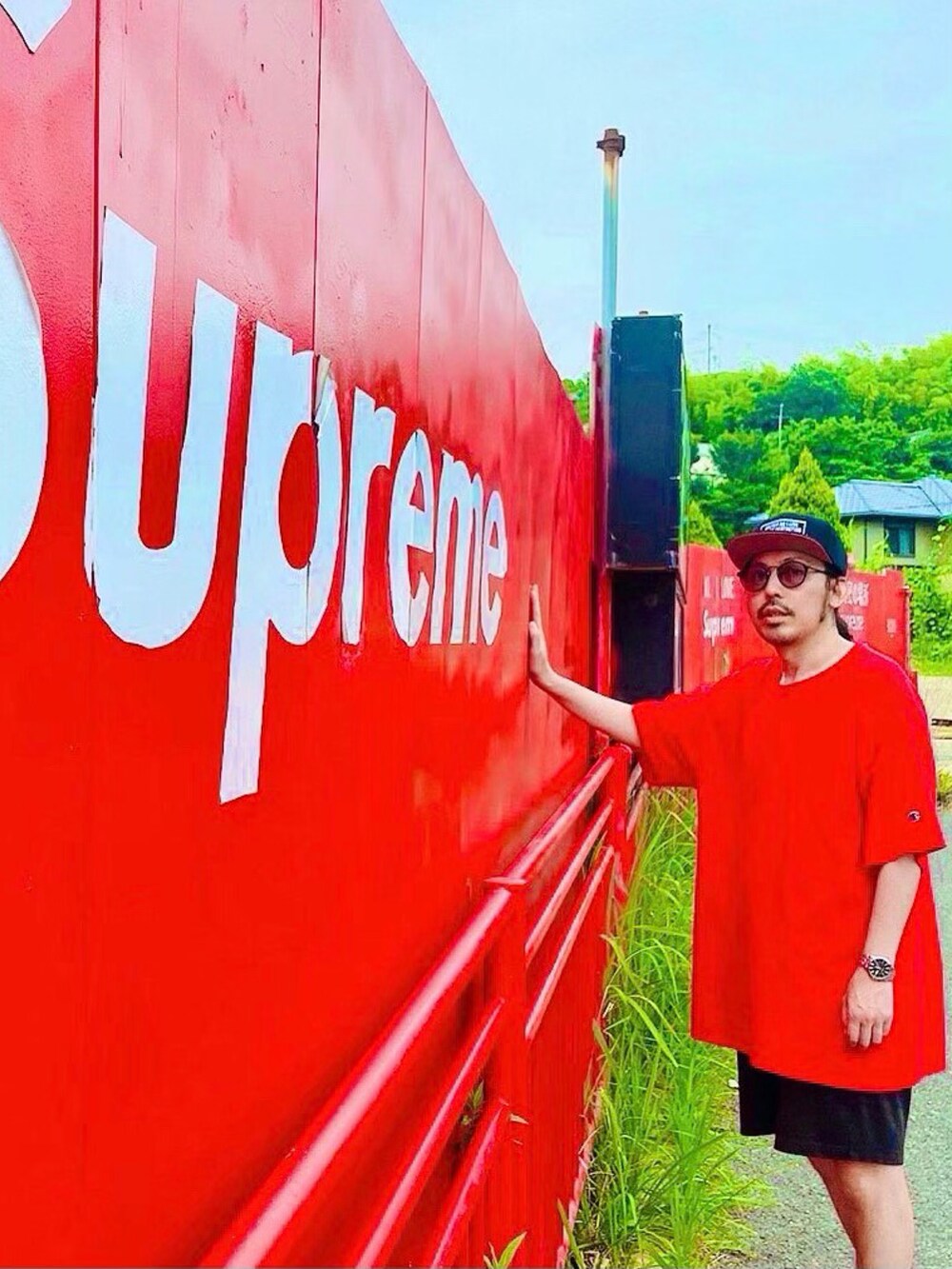 レッド系のTシャツ/カットソー、ブラック系のサンダル、ブラック系のキャップを着用したメンズの春コーディネートの2枚目の写真