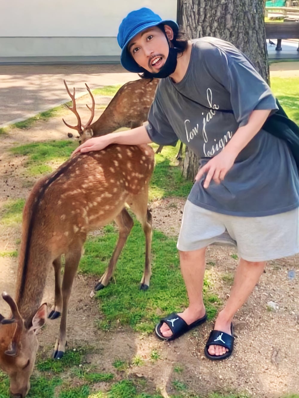 ブラック系のサンダル、ブルー系のハットを着用したメンズの春コーディネートの2枚目の写真