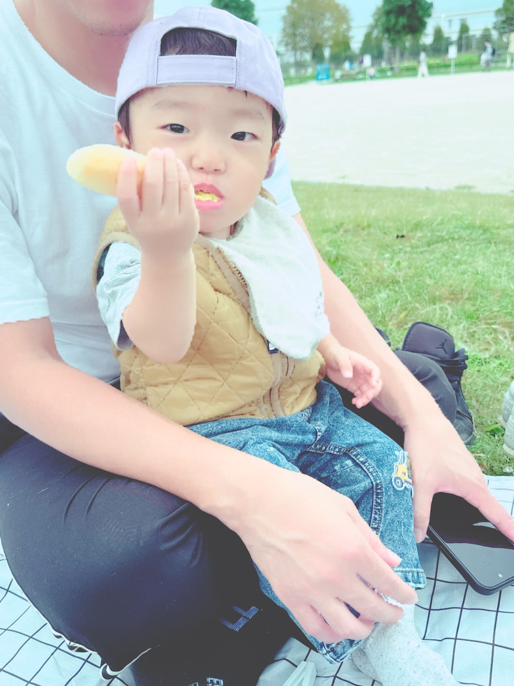 ベージュ系のベスト、グレー系のスニーカー、パープル系のキャップを着用したキッズの秋コーディネートの3枚目の写真