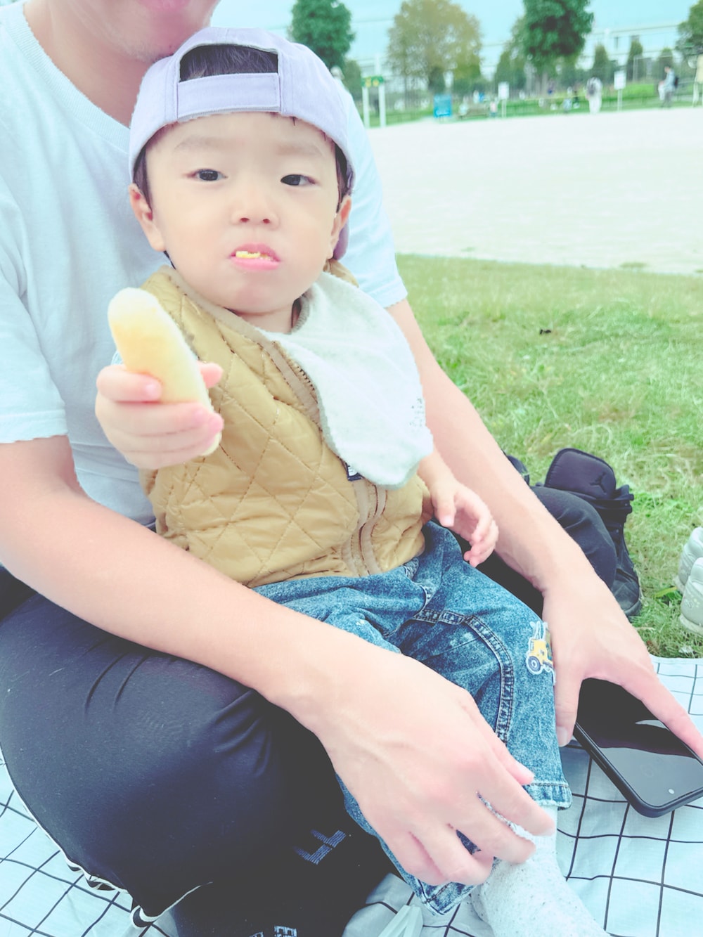 ベージュ系のベスト、グレー系のスニーカー、パープル系のキャップを着用したキッズの秋コーディネートの4枚目の写真