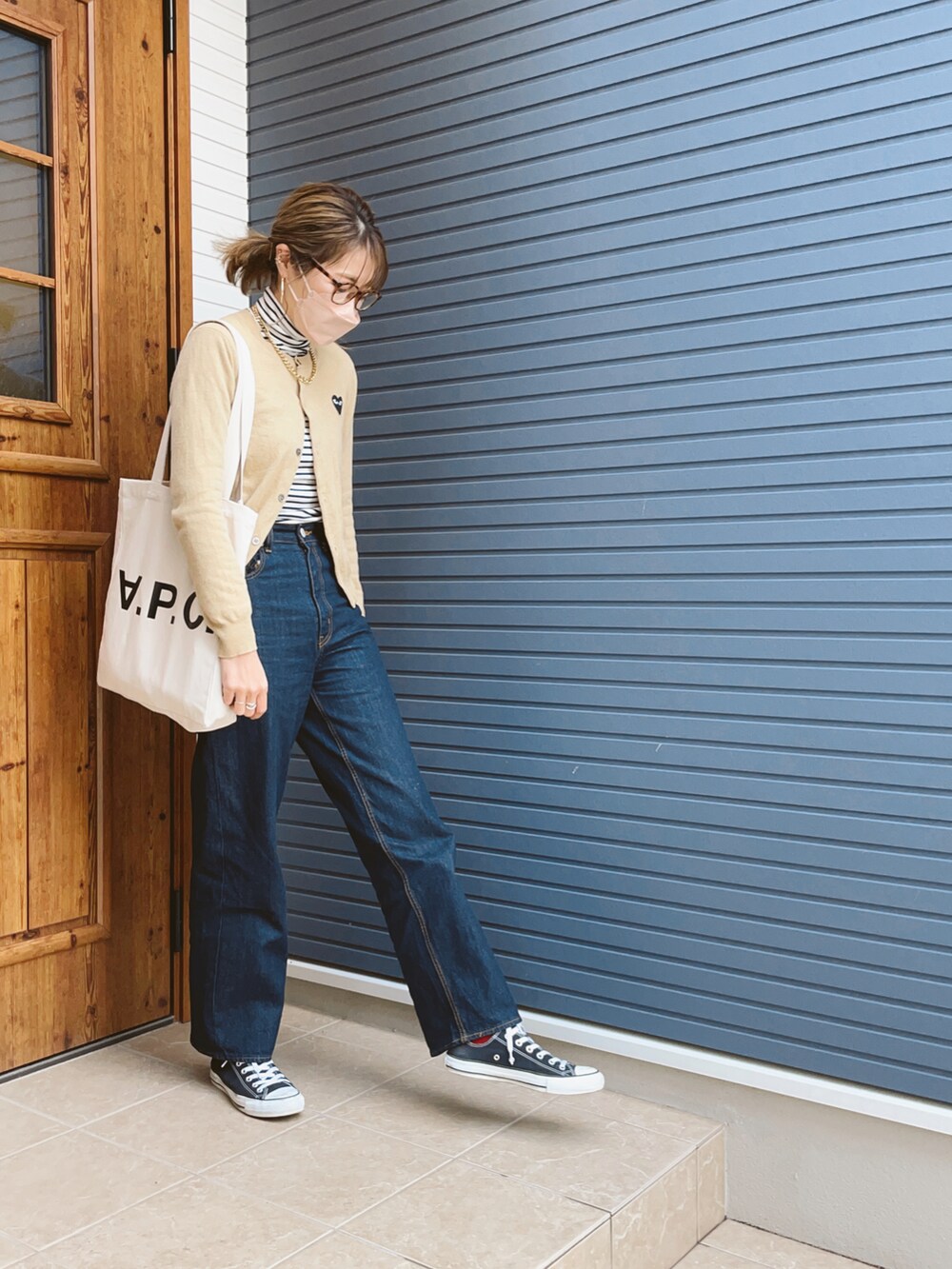 ホワイト系のトートバッグ、ブルー系のデニムパンツを着用したレディースの冬コーディネートの2枚目の写真