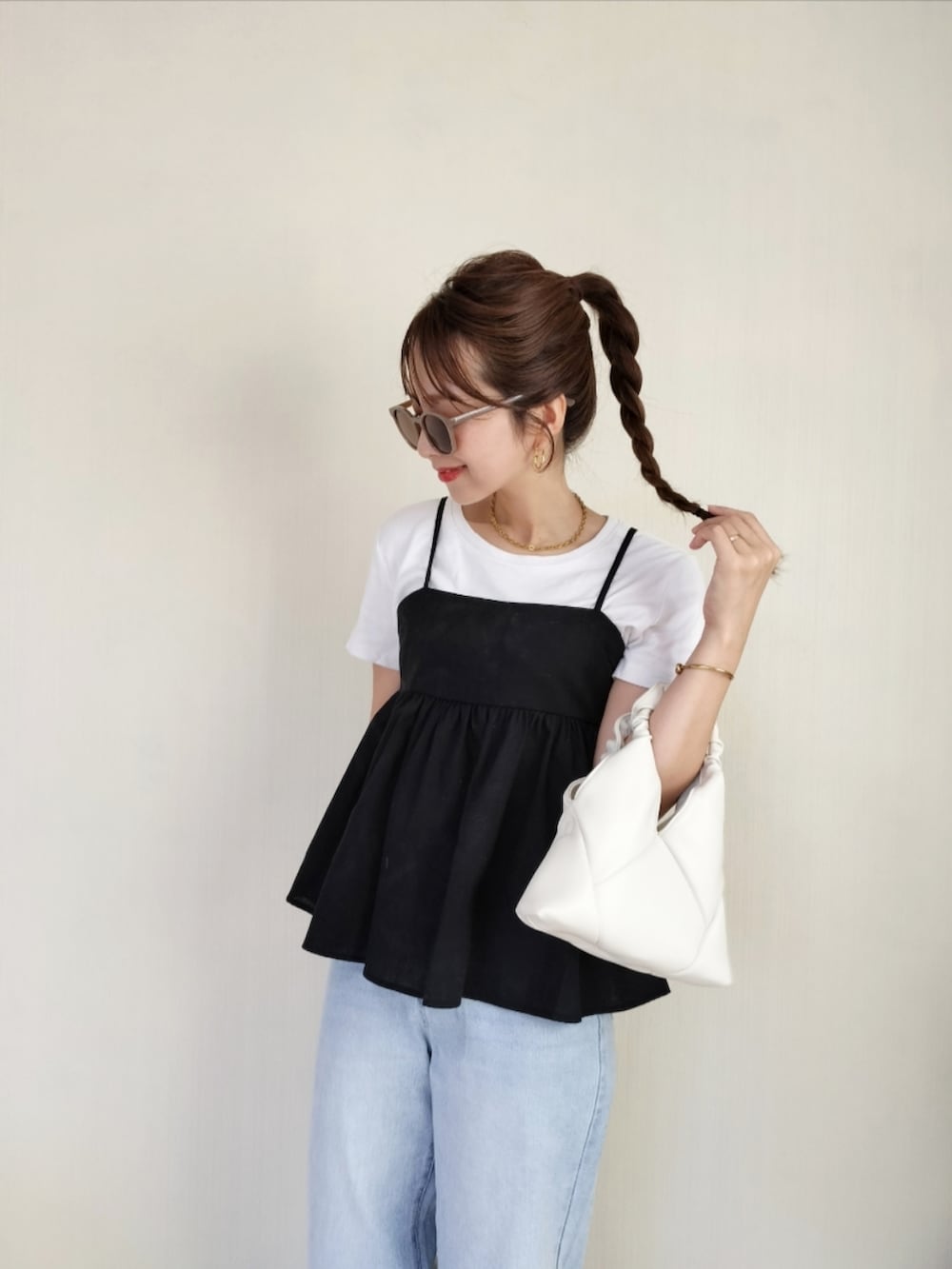 ホワイト系のショルダーバッグ、ブラック系のキャミソールを着用したレディースの夏コーディネートの4枚目の写真