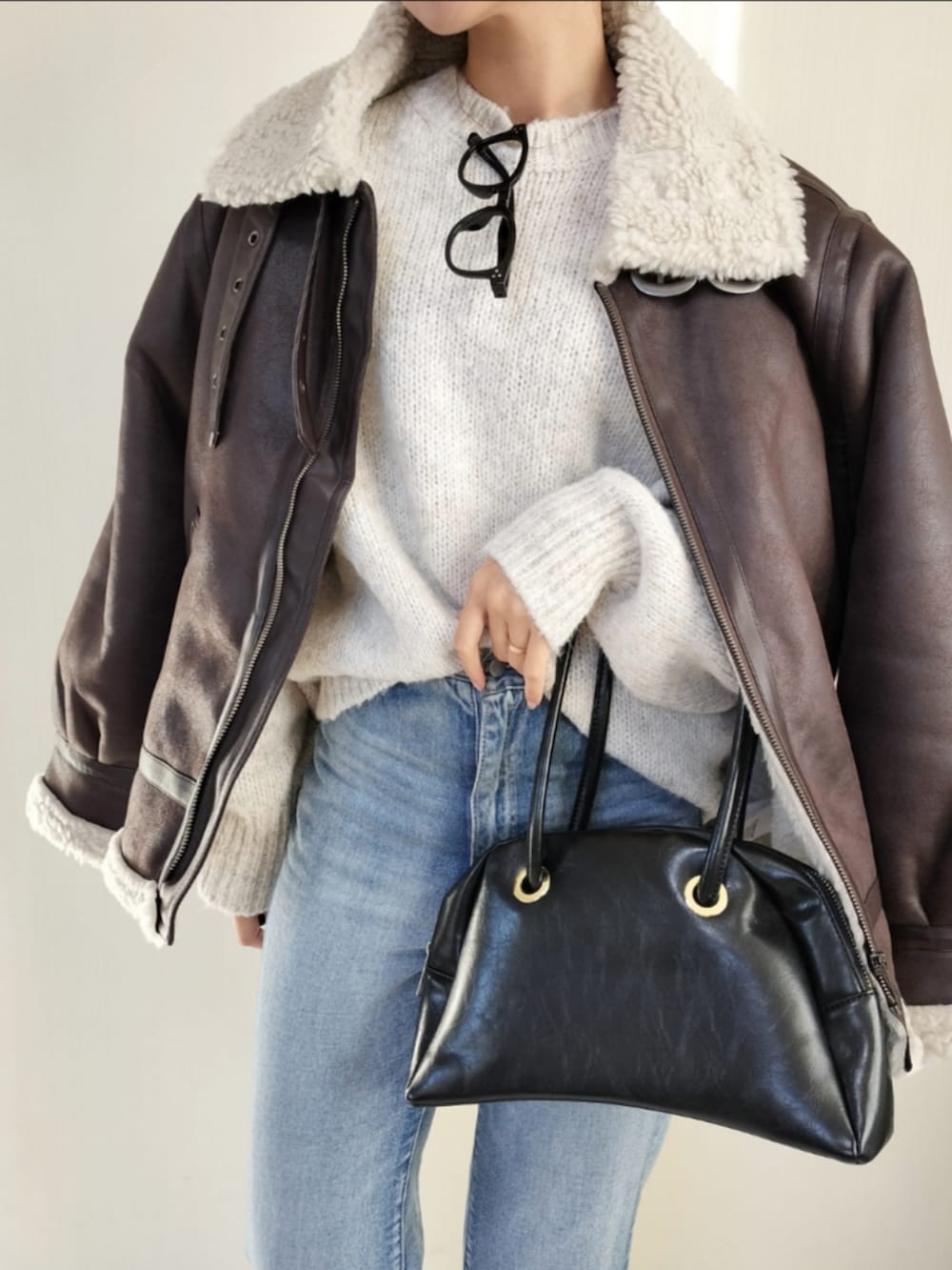 ホワイト系のニット/セーター、ブラウン系のムートンコートを着用したレディースの秋コーディネートの2枚目の写真