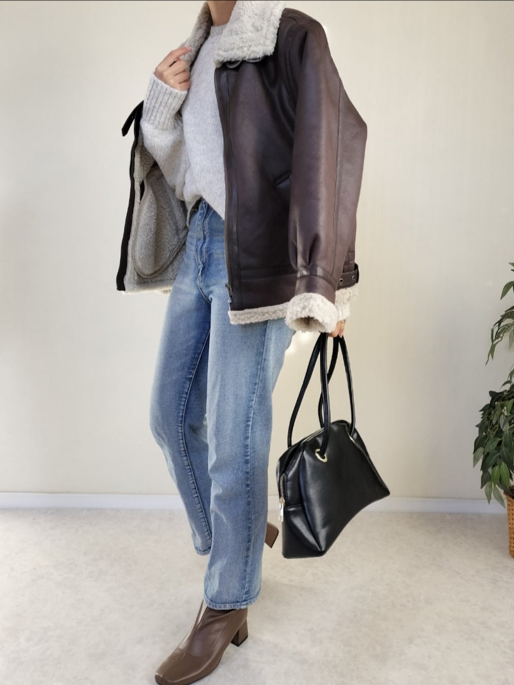 ホワイト系のニット/セーター、ブラウン系のムートンコートを着用したレディースの秋コーディネートの4枚目の写真