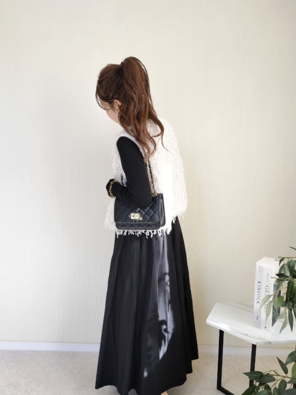 ホワイト系のトップスを着用したレディースの秋コーディネートの2枚目の写真