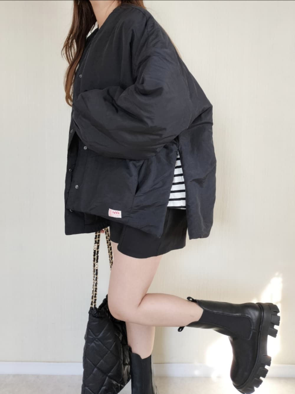 ブラック系のノーカラージャケットを着用したレディースの秋コーディネートの2枚目の写真