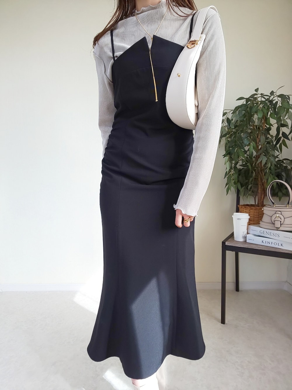 ベージュ系のTシャツ/カットソー、ブラック系のワンピース、ベージュ系のショルダーバッグを着用したレディースの春コーディネートの2枚目の写真