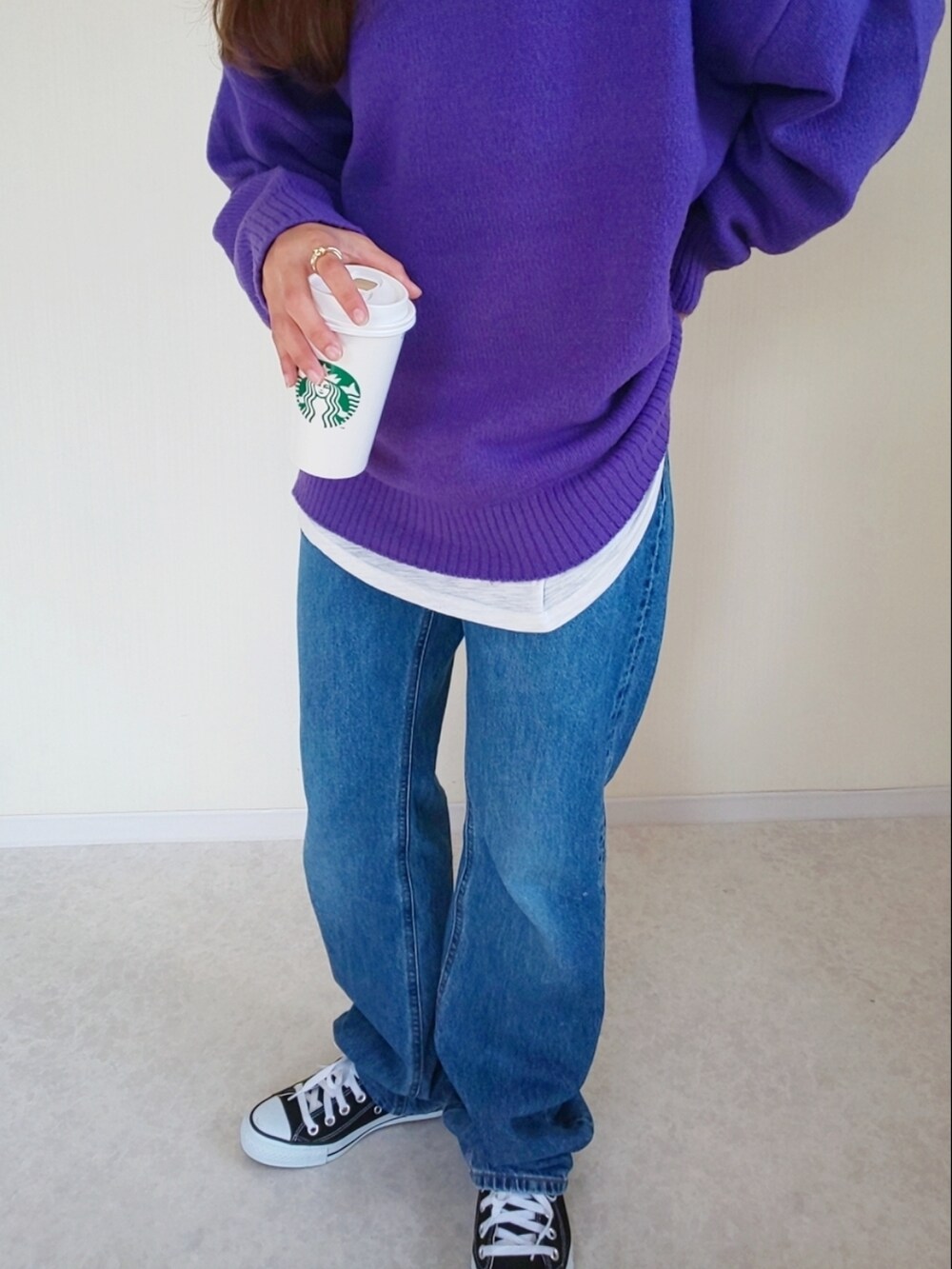 ブルー系のデニムパンツ、ブラック系のスニーカー、パープル系のニット/セーターを着用したレディースの秋コーディネートの2枚目の写真