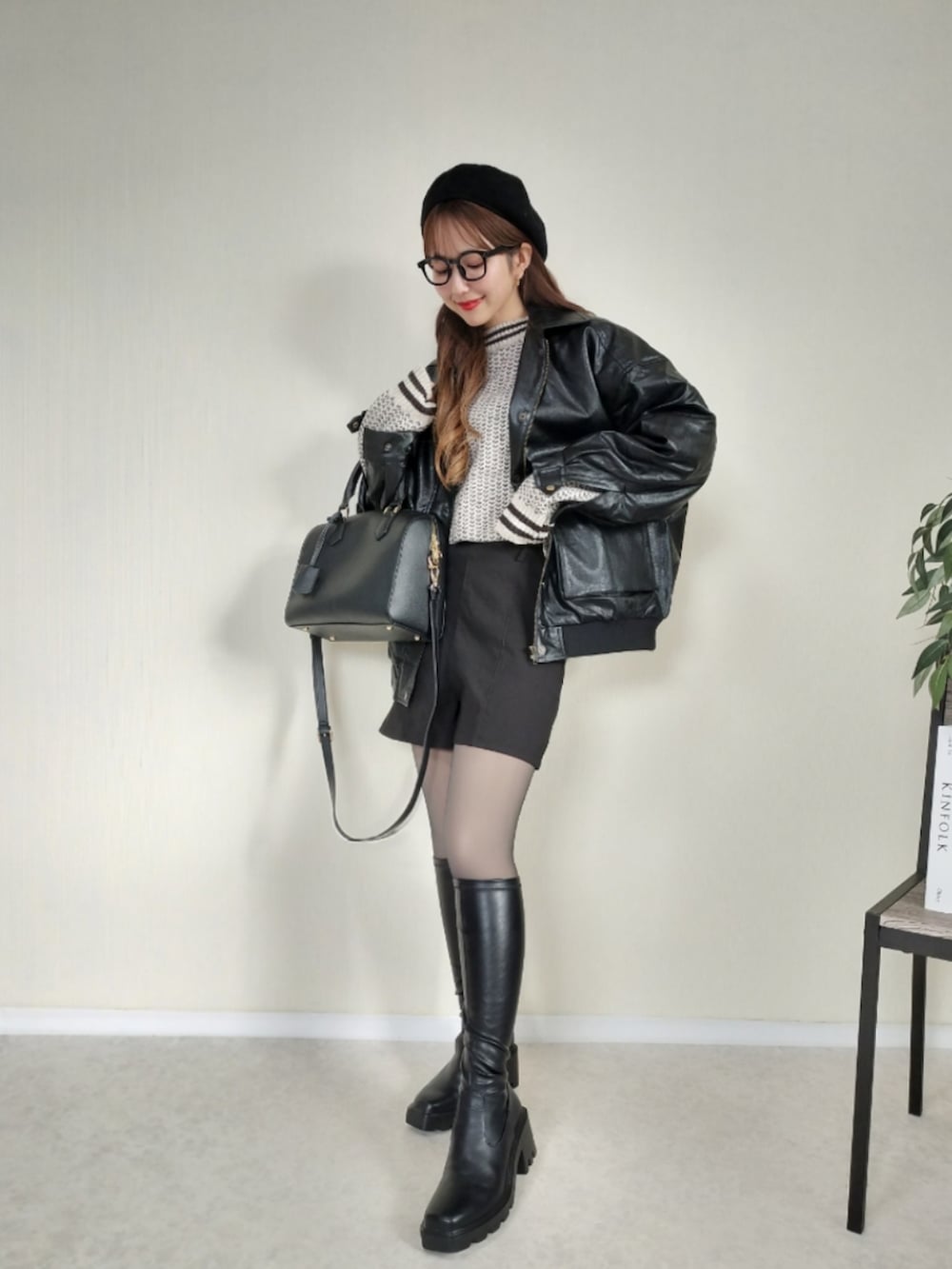 ベージュ系のニット/セーター、ブラック系のブルゾンを着用したレディースの冬コーディネートの2枚目の写真