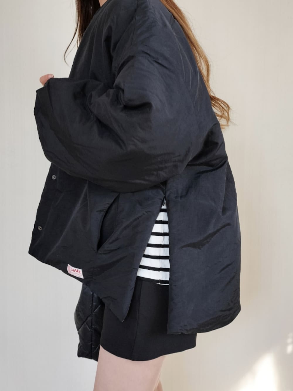 ブラック系のノーカラージャケットを着用したレディースの秋コーディネートの3枚目の写真