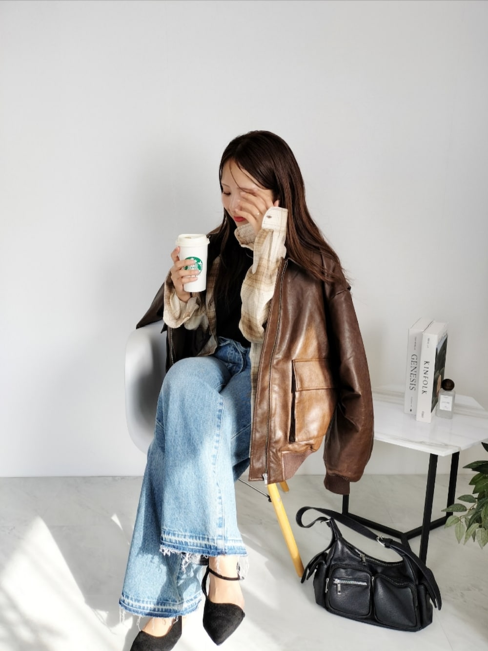 ブラウン系のブルゾン、ブルー系のデニムパンツを着用したレディースの秋コーディネートの2枚目の写真