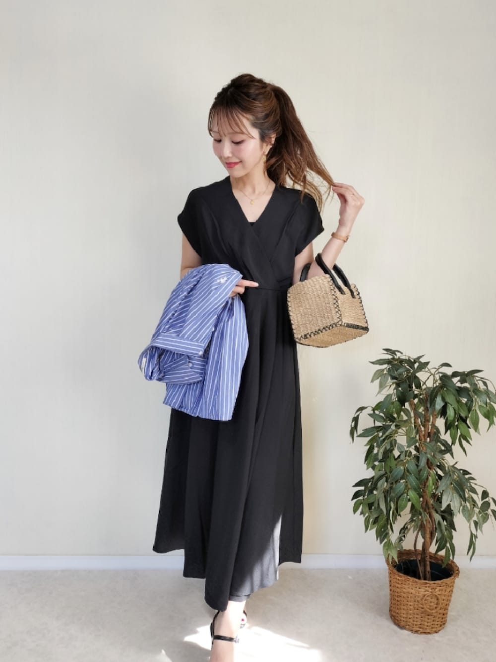 ベージュ系のかごバッグ、ブルー系のシャツ/ブラウス、ブラック系のワンピースを着用したレディースの春コーディネートの2枚目の写真