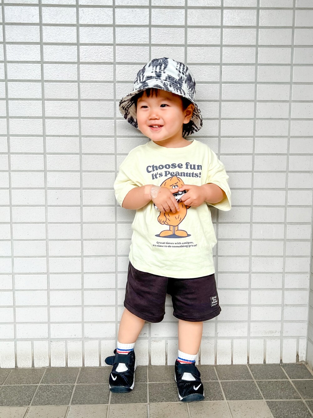 ブラック系のパンツ、イエロー系のTシャツ/カットソー、ブラック系のサンダルを着用したキッズの春コーディネートの2枚目の写真