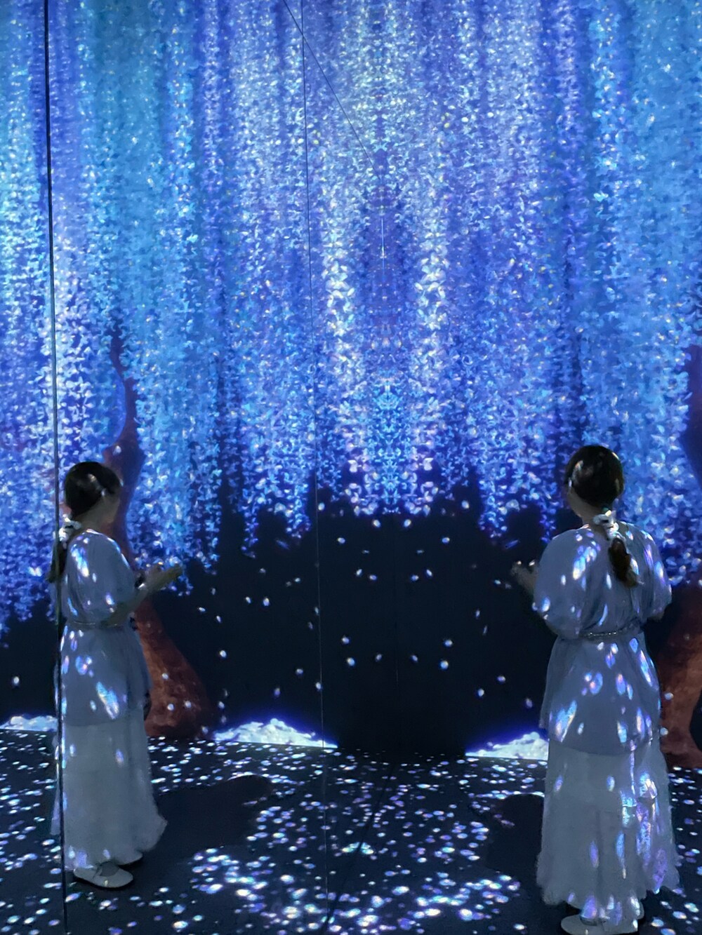 ホワイト系のスカート、ブルー系のトップスを着用したレディースの春コーディネートの2枚目の写真