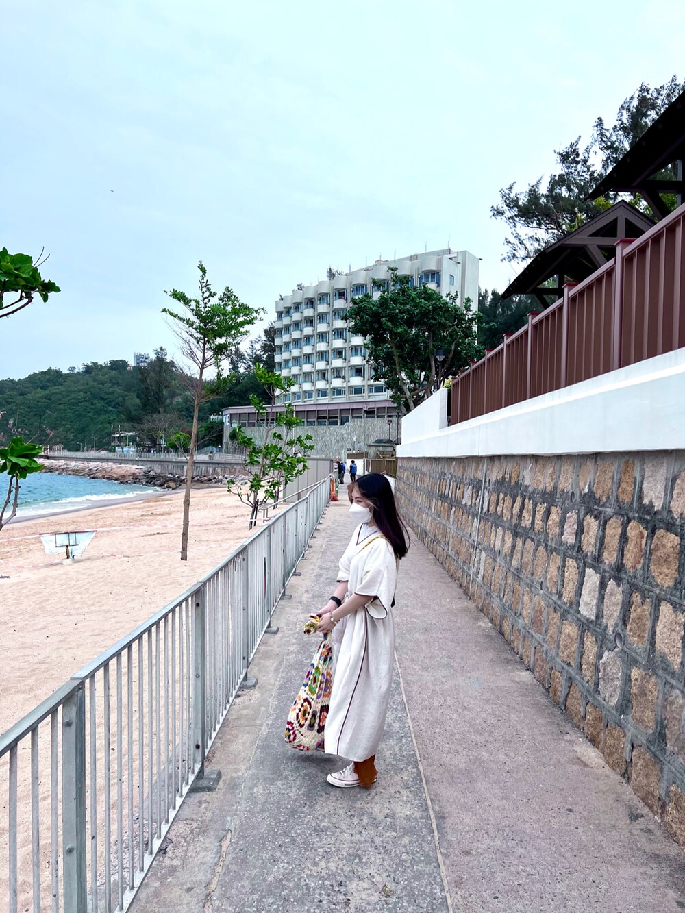 オレンジ系のチノパンツ、ベージュ系のシューズ、ベージュ系のトップスを着用したレディースの春コーディネートの2枚目の写真