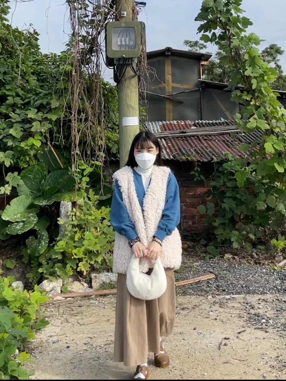 ブルー系のトップスを着用したレディースの春コーディネートの2枚目の写真